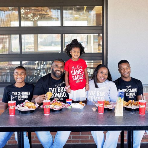 Family of five matching in Raising Canes and Kaans Shirts